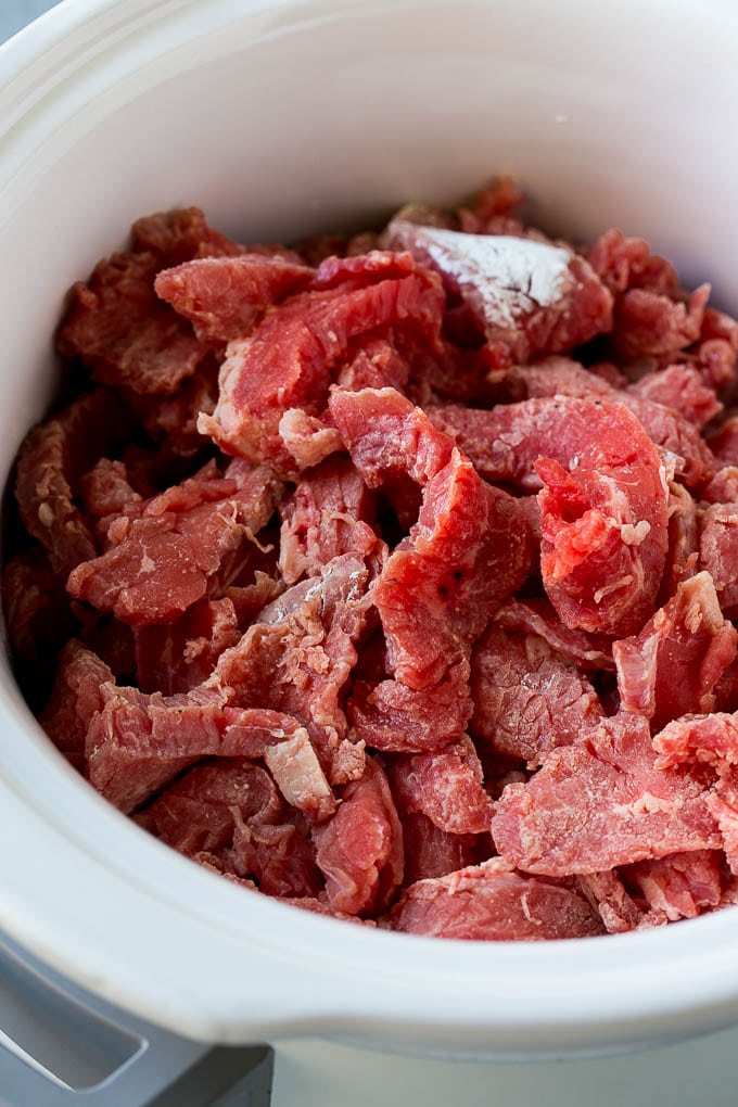 Slow Cooker Korean Beef Recipe | Korean Beef | Flank Steak Recipe #dinner #beef #slowcooker #crockpot #asian #edsug Flank steak strips tossed in cornstarch inside a slow cooker.