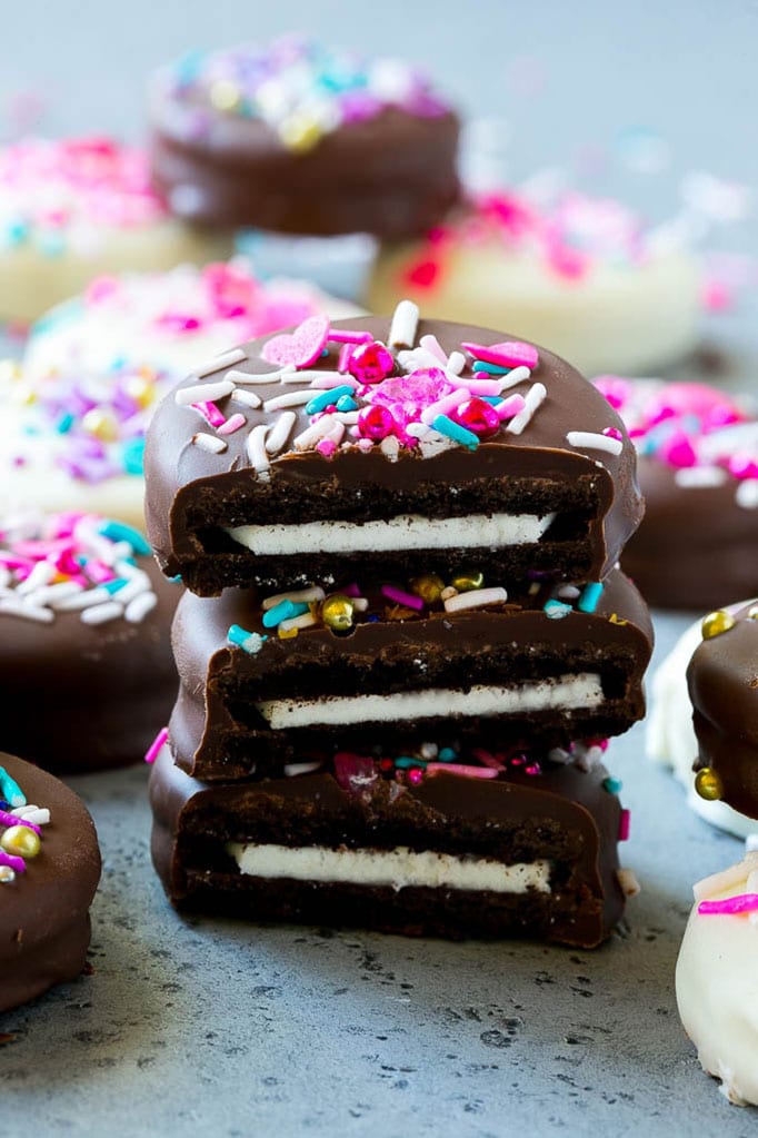 Chocolate Covered Oreos Recipe | Oreo Cookies | Chocolate Dipped Oreos #oreo #cookies #chocolate #sprinkles #dessert #edsug Three chocolate covered Oreos stacked on top of each other.