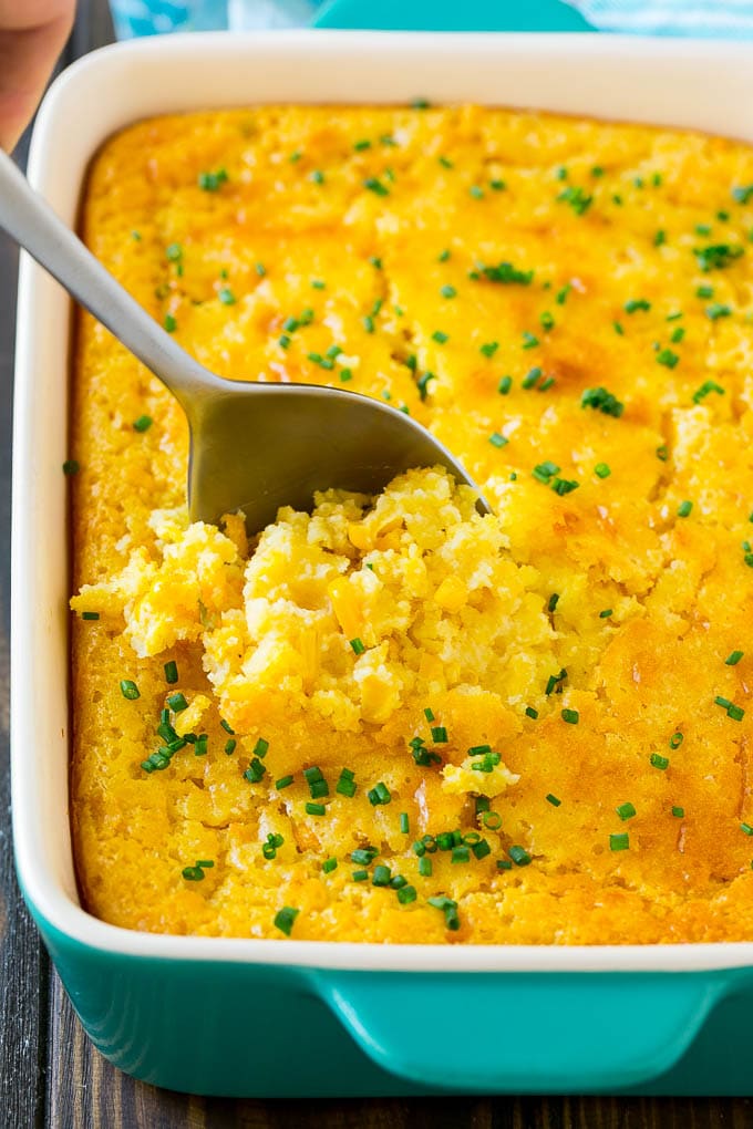 Corn Pudding Recipe | Corn Casserole | Corn Side Dish #corn #pudding #casserole #sidedish #thanksgiving #dinner #edsug A pan of corn pudding with a serving spoon in it.