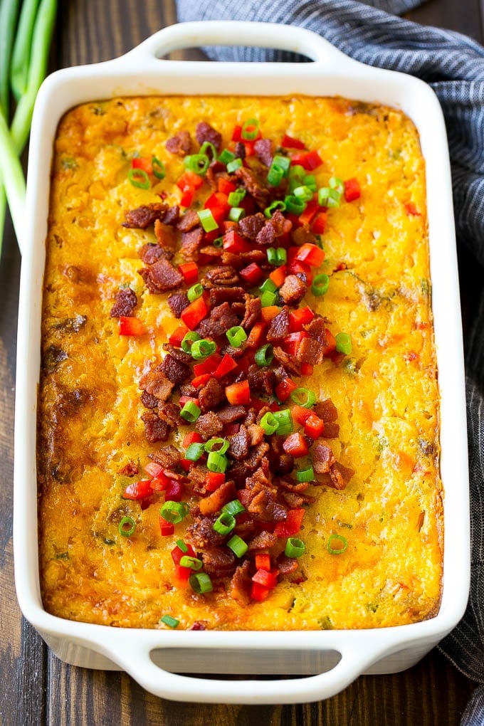 Loaded Corn Casserole Recipe | Easy Corn Casserole | Bacon Corn Casserole | Corn Pudding #corn #casserole #bacon #cheese #sidedish #thanksgiving #dinner #edsug A casserole of loaded corn casserole topped with bacon, red peppers and green onions.