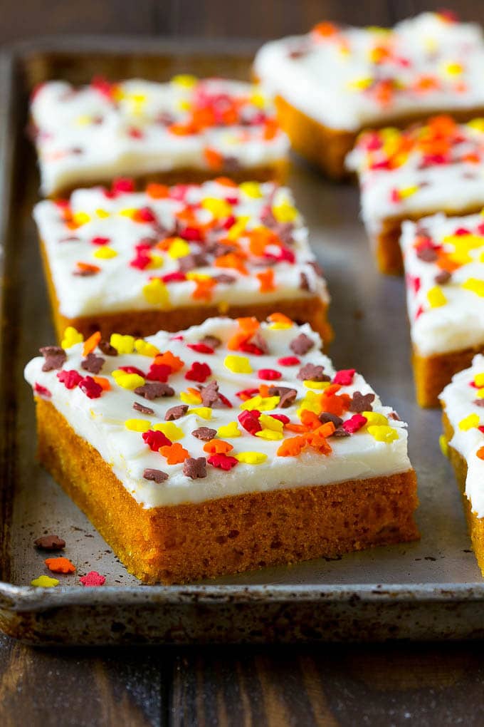 Pumpkin Bars Recipe | Pumpkin Cake | Pumpkin Dessert #pumpkin #fall #dessert #edsug #thanksgiving A baking sheet of frosted pumpkin bars.