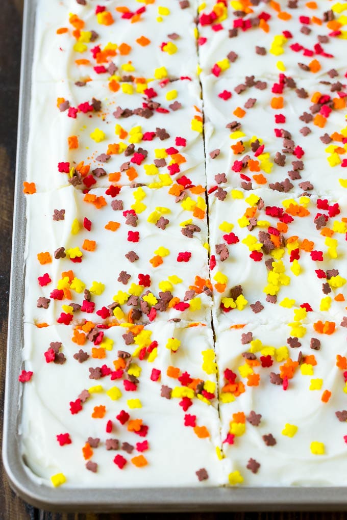 Pumpkin Bars Recipe | Pumpkin Cake | Pumpkin Dessert #pumpkin #fall #dessert #edsug #thanksgiving Cream cheese frosting and sprinkles spread over cake.