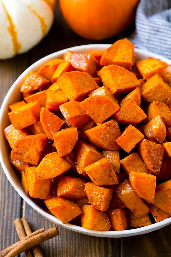 Maple Roasted Sweet Potatoes Recipe | Easy Sweet Potatoes | Baked Sweet Potatoes | Sweet Potato Side Dish #sweetpotatoes #cinnamon #maple #butter #fall #sidedish #dinner #edsug A bowl of maple roasted sweet potatoes with cinnamon and butter on top.