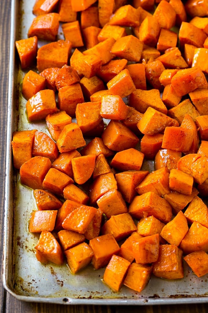 Maple Roasted Sweet Potatoes Recipe | Easy Sweet Potatoes | Baked Sweet Potatoes | Sweet Potato Side Dish #sweetpotatoes #cinnamon #maple #butter #fall #sidedish #dinner #edsug A sheet pan of roasted sweet potatoes.