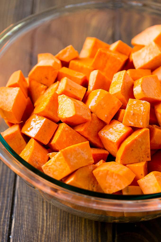 Maple Roasted Sweet Potatoes Recipe | Easy Sweet Potatoes | Baked Sweet Potatoes | Sweet Potato Side Dish #sweetpotatoes #cinnamon #maple #butter #fall #sidedish #dinner #edsug A bowl of peeled and diced yams.