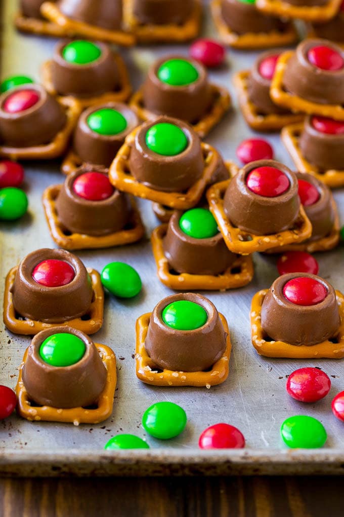 Rolo Pretzels Recipe | Chocolate Pretzels | Caramel Pretzels | Holiday Candy #christmas #baking #dessert #candy #chocolate #caramel #pretzels #edsug Rolo pretzels on a baking sheet topped with red and green M&M's.