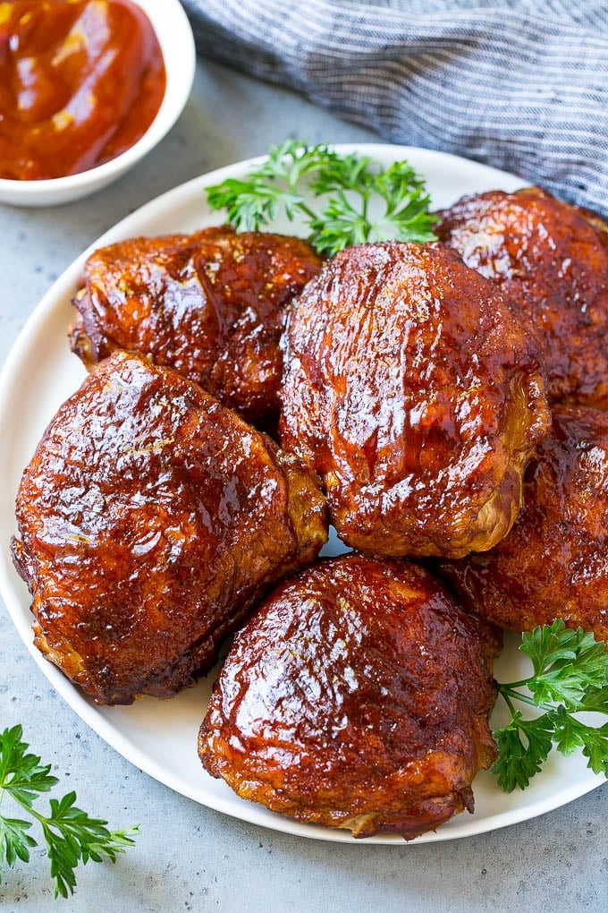 Smoked Chicken Thighs Recipe | Barbecue Chicken Thighs | Easy Chicken Thighs #chicken #barbecue #smoker #dinner #edsug A plate of smoked chicken thighs coated in spice rub and barbecue sauce.
