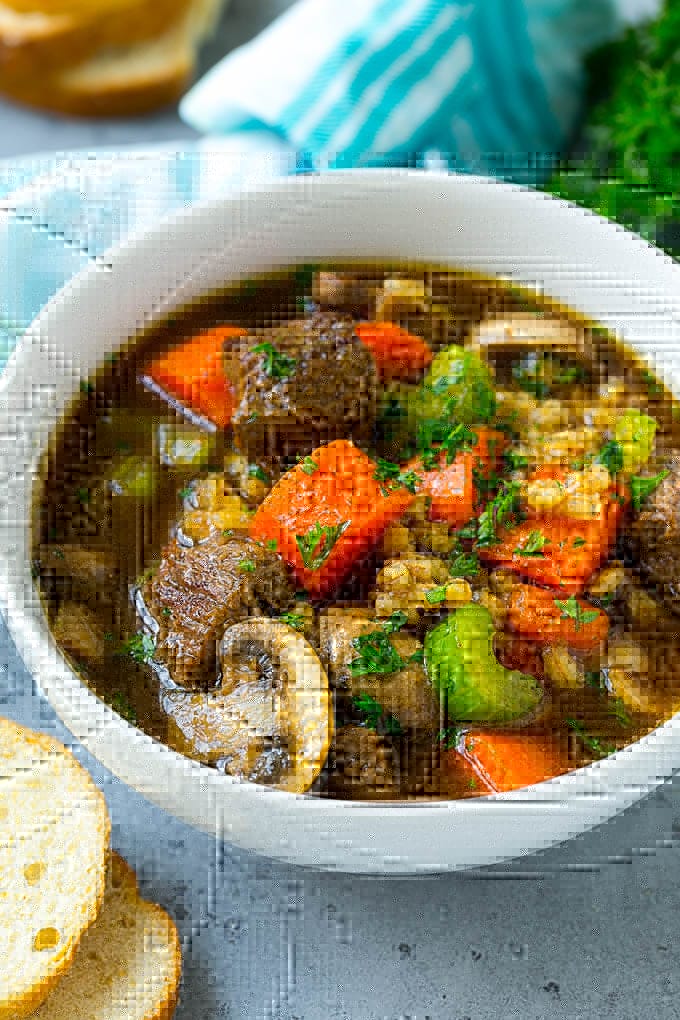Beef Barley Soup Recipe | Beef Soup | Barley Soup #soup #beef #dinner #vegetables #edsug #comfortfood A bowl of beef barley soup topped with chopped parsley.