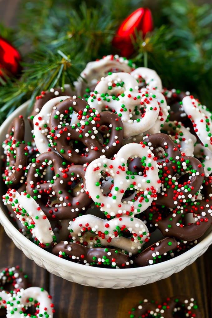 Chocolate Covered Pretzels Recipe | Sprinkle Pretzels | No Bake Dessert #pretzels #chocolate #christmas #sprinkles #candy #edsug Chocolate covered pretzels in a bowl with Christmas sprinkles.
