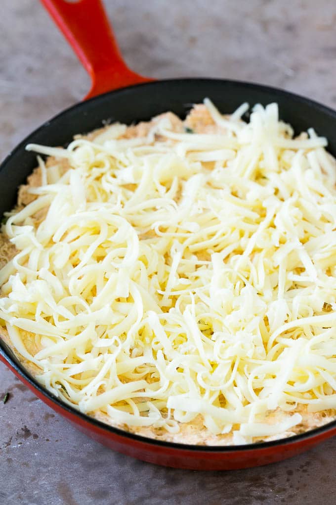 Crab Dip Recipe | Hot Crab Dip | Seafood Dip #dip #crab #seafood #appetizer #edsug #cheese Shredded Monterey Jack cheese sprinkled over a skillet of mixture.