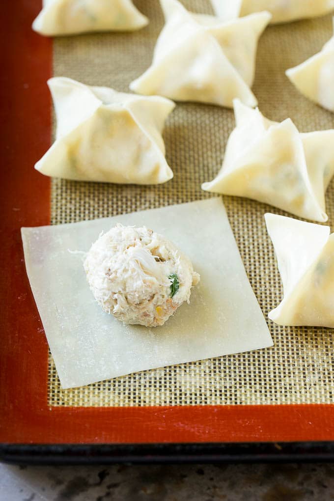 Crab Rangoon Recipe | Crab Wontons | Cream Cheese Wontons #crab #cheese #appetizer #snack #chinesefood #dinner #edsug A wonton wrapper with a dollop of filling on it.