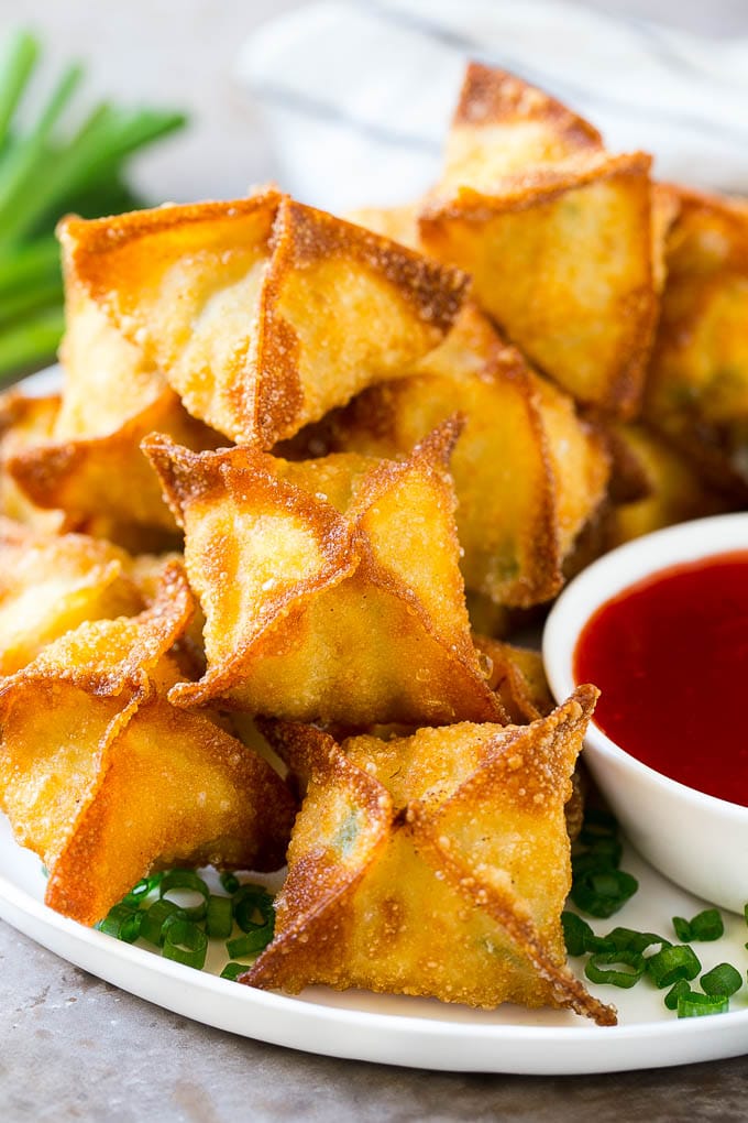 Crab Rangoon Recipe | Crab Wontons | Cream Cheese Wontons #crab #cheese #appetizer #snack #chinesefood #dinner #edsug A pile of crab rangoon wontons filled with a creamy crab mixture.