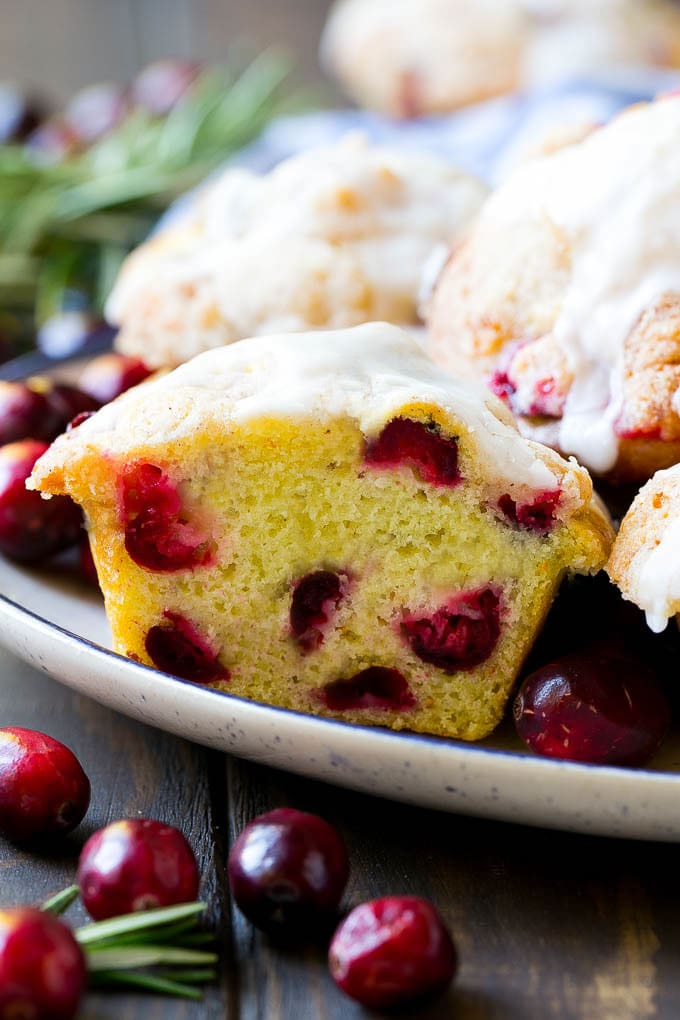 Cranberry Muffins Recipe | Cranberry Orange Muffins #cranberry #muffins #orange #fall #dessert #edsug A plate of muffins with one cut in half.
