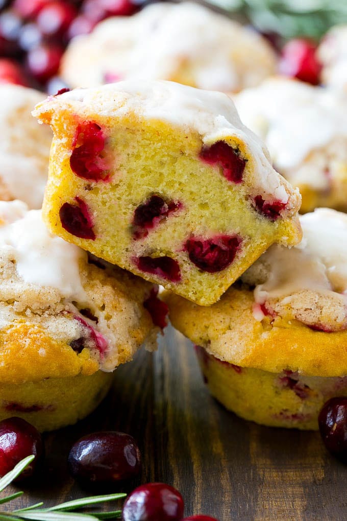 Cranberry Muffins Recipe | Cranberry Orange Muffins #cranberry #muffins #orange #fall #dessert #edsug A stack of cranberry muffins with one muffin cut in half.