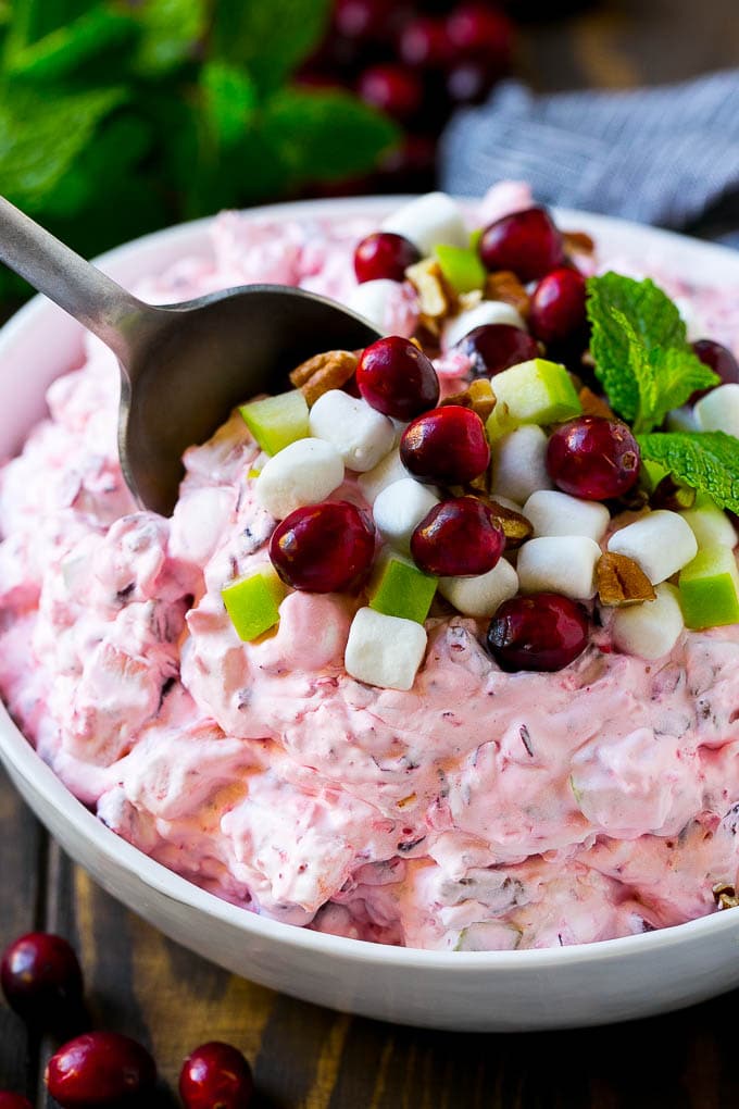 Cranberry Salad Recipe | Fluff Salad #cranberry #salad #fall #dinner #edsug #thanksgiving Cranberry salad with a serving spoon in it.