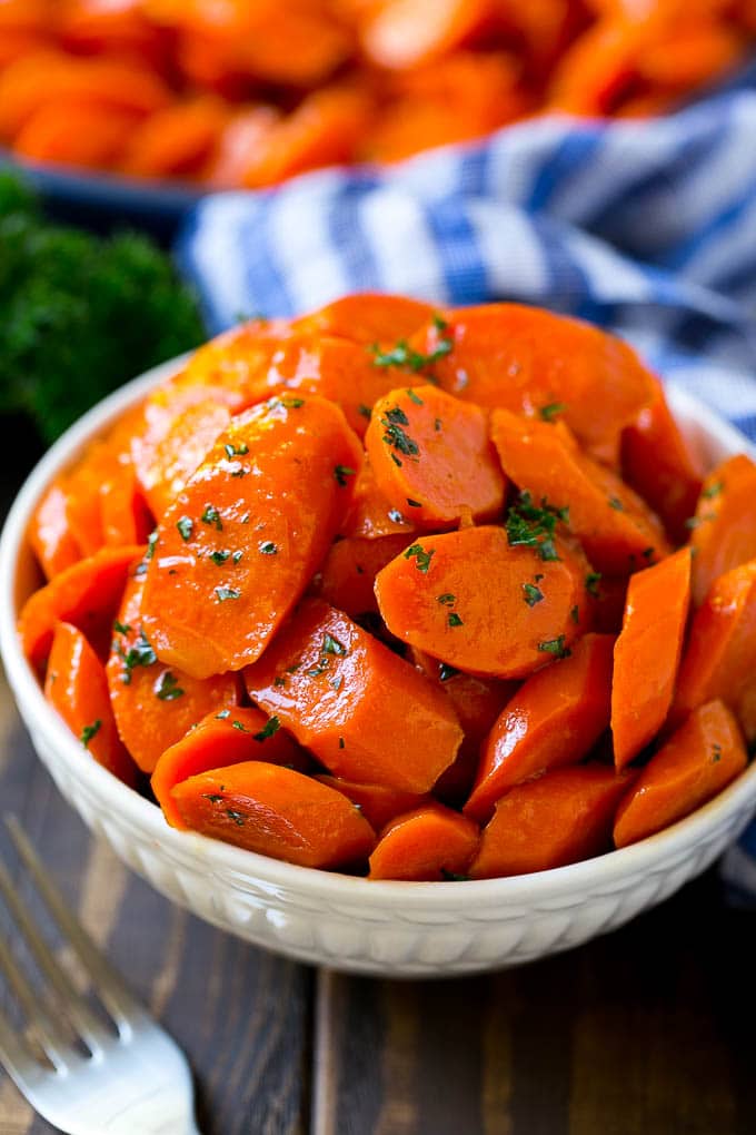 Glazed Carrots Recipe | Brown Sugar Carrots | Carrot Side Dish #carrots #brownsugar #sidedish #glutenfree #thanksgiving #fall #dinner #edsug A bowl of glazed carrots topped with parsley.