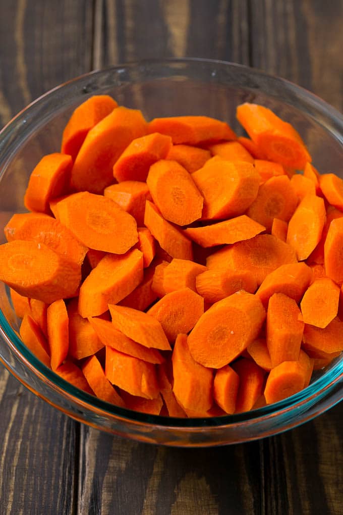 Glazed Carrots Recipe | Brown Sugar Carrots | Carrot Side Dish #carrots #brownsugar #sidedish #glutenfree #thanksgiving #fall #dinner #edsug A bowl of peeled and sliced carrots.