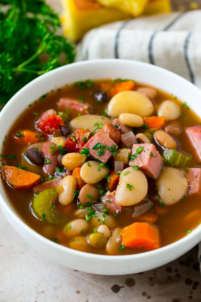 Ham and Bean Soup Recipe | Slow Cooker Ham and Bean Soup | Crockpot Ham and Bean Soup | Leftover Ham Recipe #ham #beans #soup #slowcooker #crockpot #dinner #edsug A bowl of ham and bean soup made with dried beans, ham and vegetables, then topped with fresh parsley.
