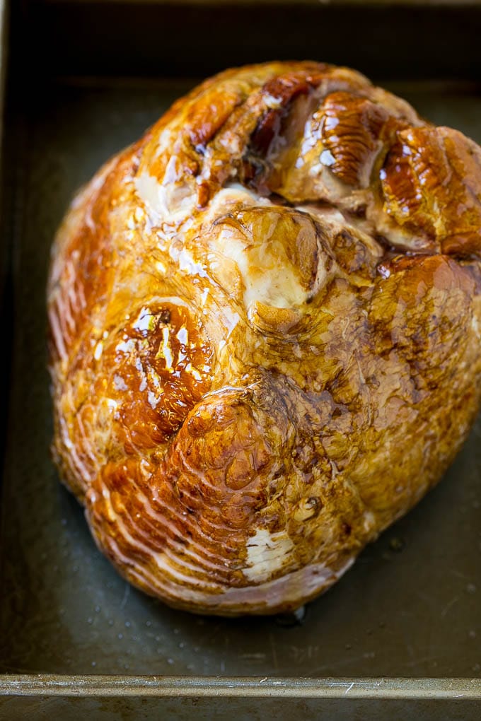 Honey Baked Ham Recipe | Glazed Ham | Holiday Ham #ham #dinner #edsug #christmas #thanksgiving #easter A honey coated ham, face down, in a baking dish.