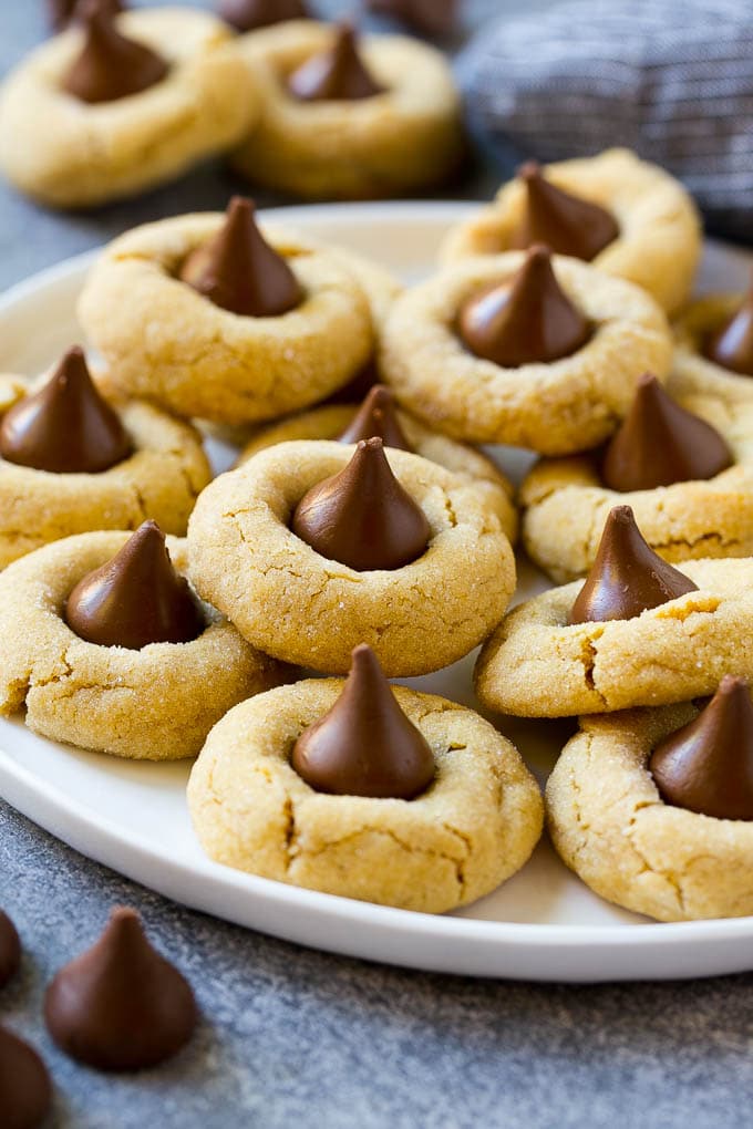 Peanut Butter Blossoms Recipe | Hershey Kiss Cookies | Chocolate Peanut Butter Cookies #cookies #peanutbutter #chocolate #dessert #baking #christmas #christmascookies #edsug A serving plate of peanut butter blossoms.
