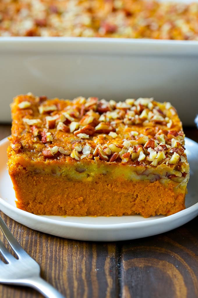Pumpkin Dump Cake Recipe | Pumpkin Cake | Pumpkin Pie Cake #pumpkin #cake #pecans #fall #thanksgiving #dessert #edsug A slice of pumpkin dump cake topped with pecans.
