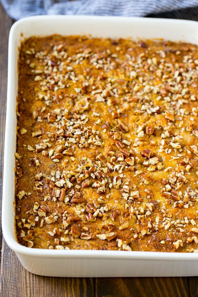 Pumpkin Dump Cake Recipe | Pumpkin Cake | Pumpkin Pie Cake #pumpkin #cake #pecans #fall #thanksgiving #dessert #edsug A pan of pumpkin dump cake topped with chopped pecans.