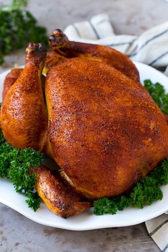 Smoked Chicken Recipe | Whole Smoked Chicken | BBQ Chicken #chicken #smoker #BBQ #dinner #edsug #glutenfree #lowcarb Smoked chicken on a serving platter garnished with parsley.