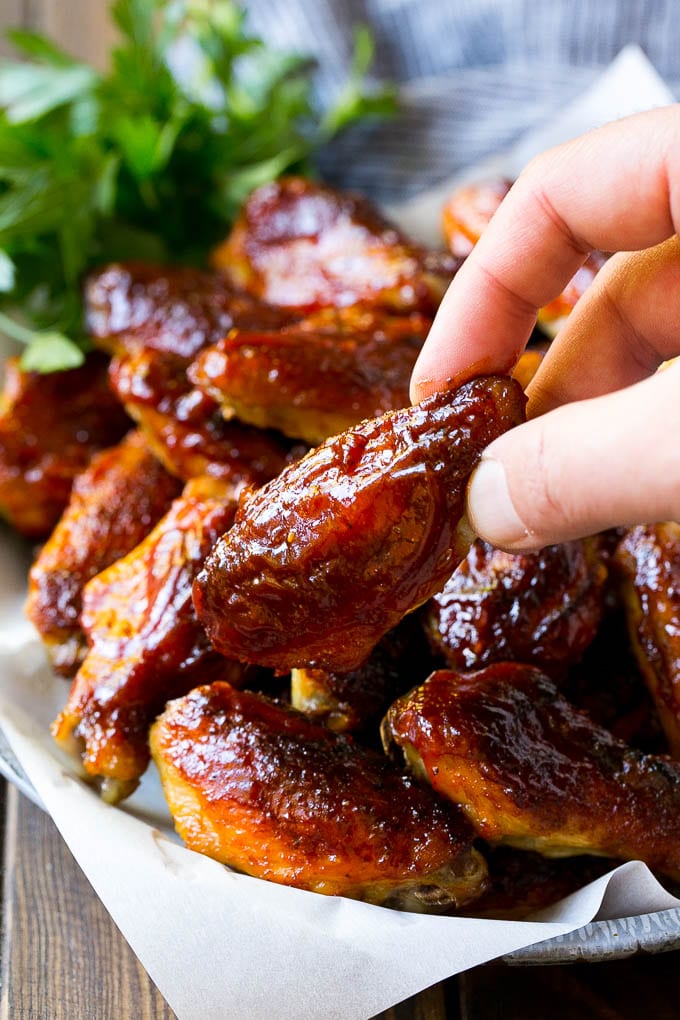 Smoked Chicken Wings | Barbecue Chicken Wings | BBQ Chicken Wings #chicken #wings #bbq #barbecue #appetizer #dinner #edsug A pile of smoked chicken wings with a hand reaching out for one.
