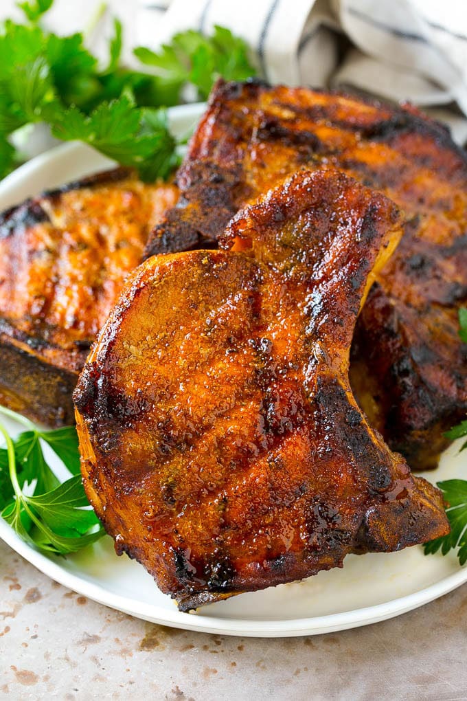 A plate of smoked pork chops garnished with fresh parsley.