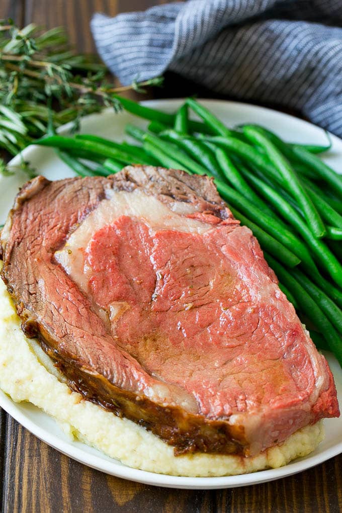Smoked Prime Rib Recipe | Easy Prime Rib | Smoked Beef | Holiday Prime Rib #primerib #beef #smoker #dinner #edsug #christmas #thanksgiving #lowcarb #keto A slice of prime rib over mashed potatoes with green beans on the side.