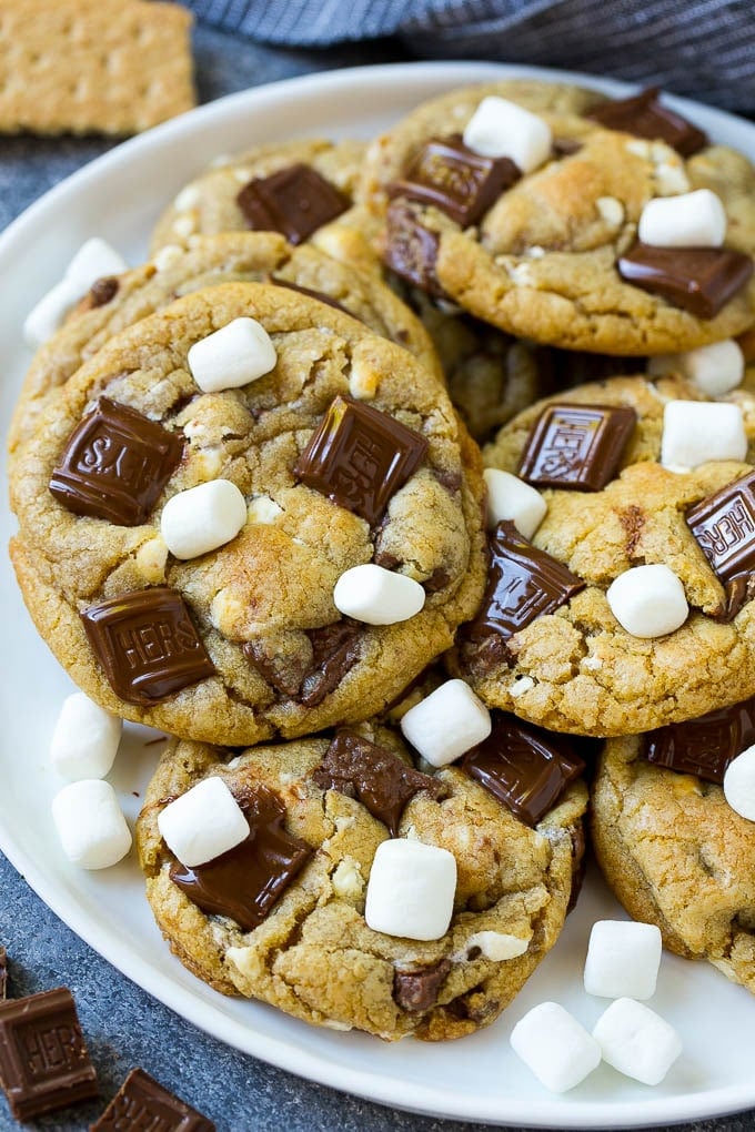 S'mores Cookies Recipe | Marshmallow Cookies #smores #marshmallow #chocolate #cookies #dessert #edsug A plate of S'mores cookies topped with milk chocolate bars and marshmallows.