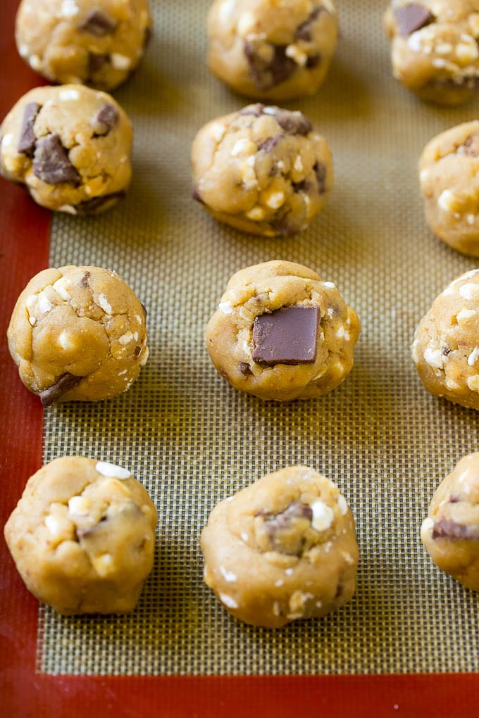 S'mores Cookies Recipe | Marshmallow Cookies #smores #marshmallow #chocolate #cookies #dessert #edsug Balls of cookie dough on a baking sheet.