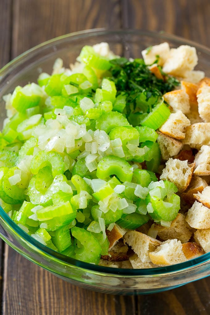 Turkey Stuffing Recipe | Thanksgiving Stuffing | Classic Stuffing #thanksgiving #stuffing #sidedish #fall #edsug Bread cubes, celery, onion and herbs in a mixing bowl.