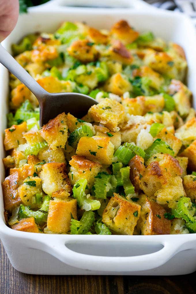 Turkey Stuffing Recipe | Thanksgiving Stuffing | Classic Stuffing #thanksgiving #stuffing #sidedish #fall #edsug Turkey stuffing in a casserole dish with a serving spoon in it.