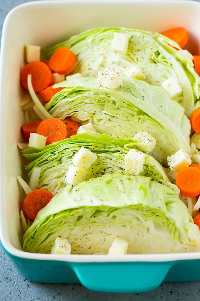 Braised Cabbage Recipe | Easy Cabbage Recipe #cabbage #lowcarb #keto #carrots #veggies #vegetarian #dinner #edsug Cabbage, carrots, onions, pieces of butter and seasonings in a baking dish.