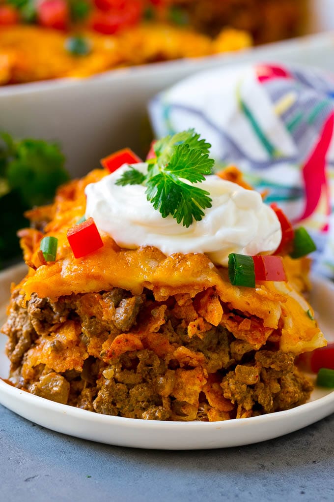 Dorito Casserole Recipe | Mexican Casserole | Beef Casserole #mexicanfood #beef #groundbeef #casserole #dinner #edsug A piece of Dorito casserole with layers of tortilla chips, beef and cheese.