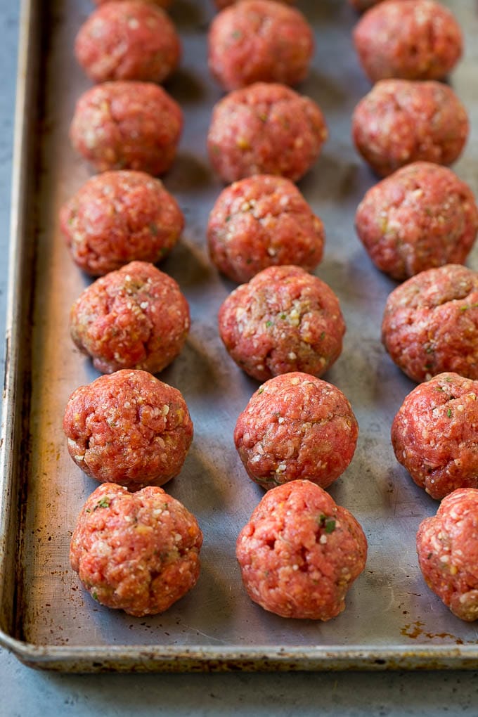 Italian Meatball Soup Recipe | Meatball Soup | Beef Meatballs #meatballs #beef #soup #italian #dinner #edsug #comfortfood Raw meatballs on a sheet pan ready to go into the oven.