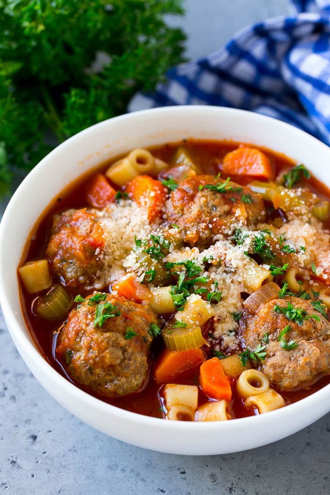 Italian Meatball Soup Recipe | Meatball Soup | Beef Meatballs #meatballs #beef #soup #italian #dinner #edsug #comfortfood A bowl of meatball soup topped with chopped parsley and grated cheese.