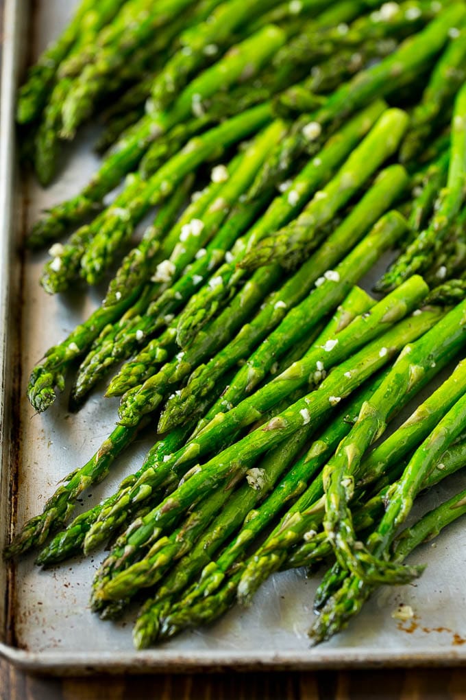 Roasted Asparagus Recipe | Baked Asparagus | Asparagus Side Dish #asparagus #garlic #sidedish #keto #lowcarb #dinner #edsug Roasted stalks with garlic and olive oil on a baking sheet.