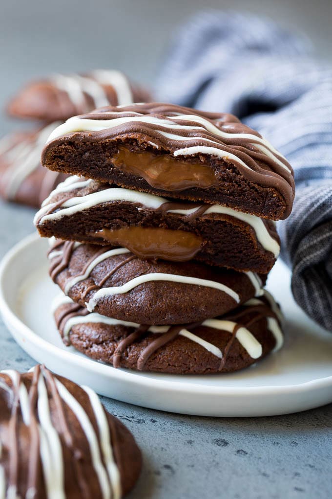 Nutella Cookies Recipe | Nutella Stuffed Cookies | Chocolate Cookies #nutella #chocolate #cookies #baking #dessert #edsug A stack of Nutella cookies on a plate with one cut open.