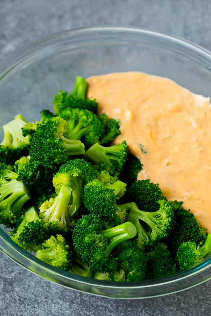 Broccoli Casserole Recipe | Broccoli and Cheese Casserole | Baked Broccoli #broccoli #cheese #casserole #sidedish #dinner #edsug Cooked florets and cheese sauce in a mixing bowl.