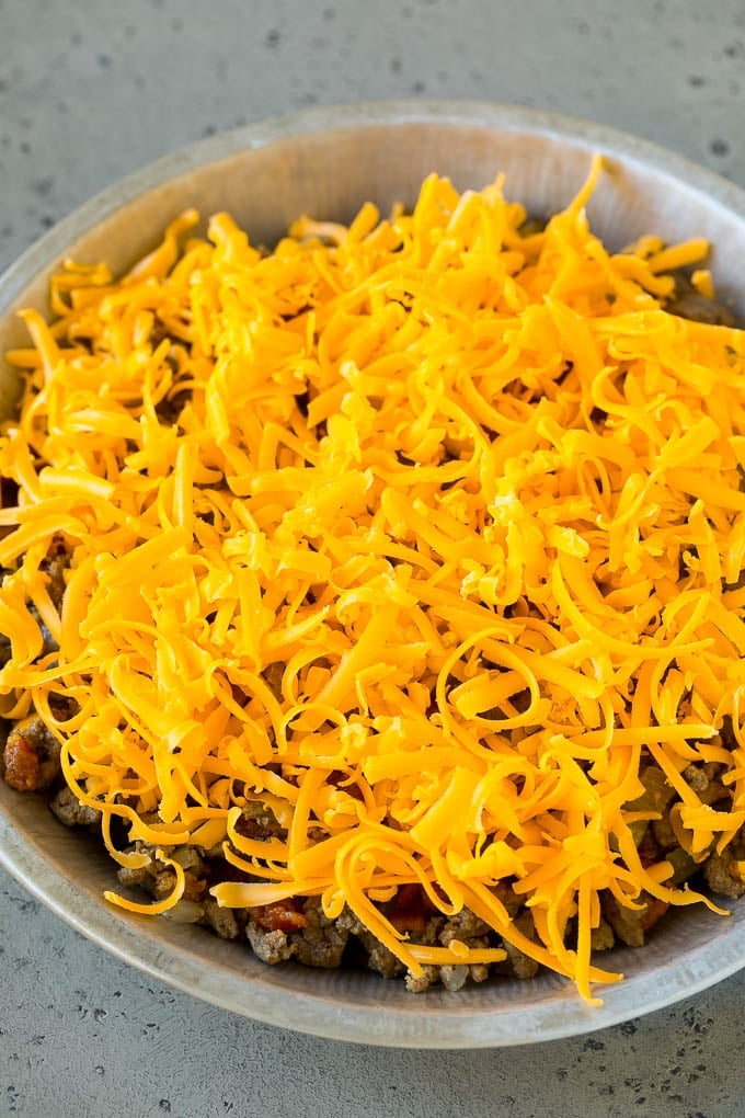 Cheeseburger Pie Recipe | Cheeseburger Casserole | Ground Beef Recipe #cheeseburger #beef #bacon #cheese #casserole #dinner #edsug Ground beef and shredded cheddar cheese in a dish.