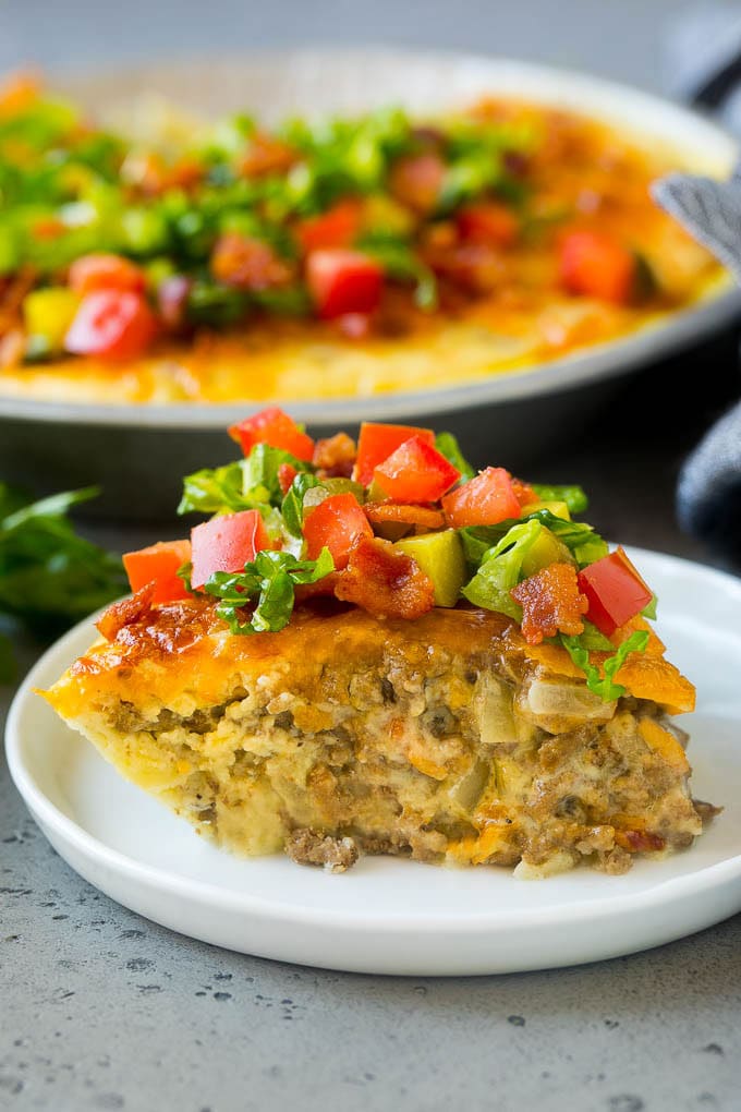 Cheeseburger Pie Recipe | Cheeseburger Casserole | Ground Beef Recipe #cheeseburger #beef #bacon #cheese #casserole #dinner #edsug A slice of cheeseburger pie garnished with shredded lettuce, diced tomatoes and pickles.