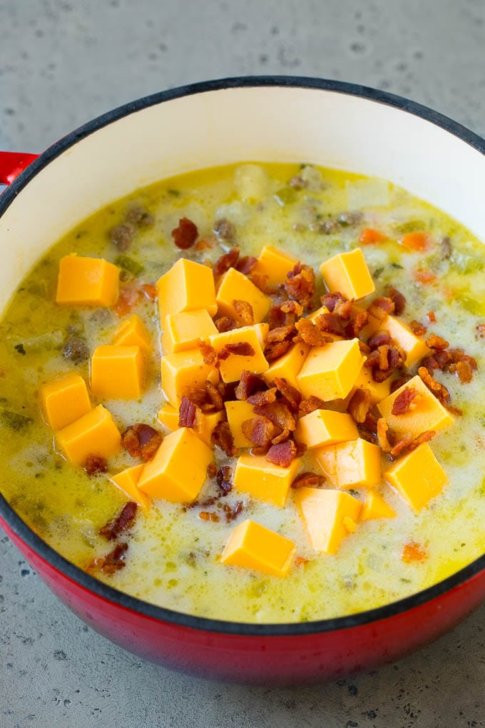 Cheeseburger Soup Recipe | Hamburger Soup | Cheese Soup #soup #groundbeef #hamburger #cheese #bacon #dinner #edsug Potato soup base with cubes of Velveeta cheese and bacon being stirred in.