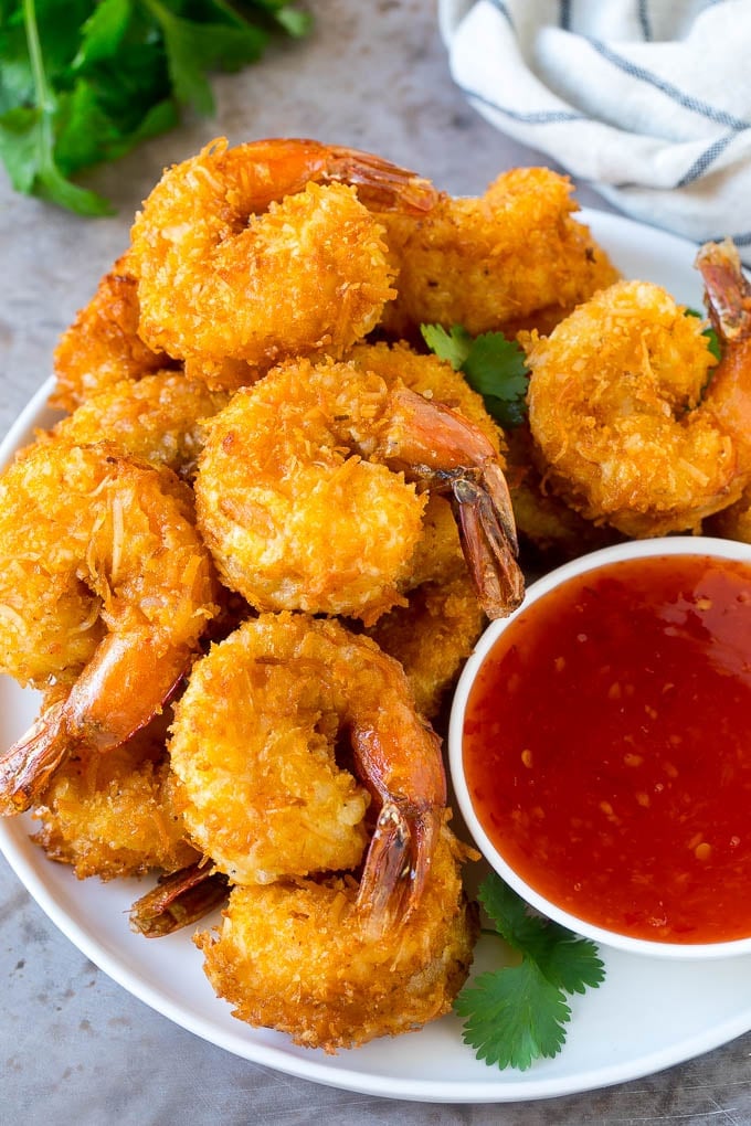 Coconut Shrimp Recipe | Fried Shrimp | Shrimp Appetizer #shrimp #coconut #appetizer #seafood #dinner #edsug A plate of coconut shrimp with a bowl of sweet chili sauce.