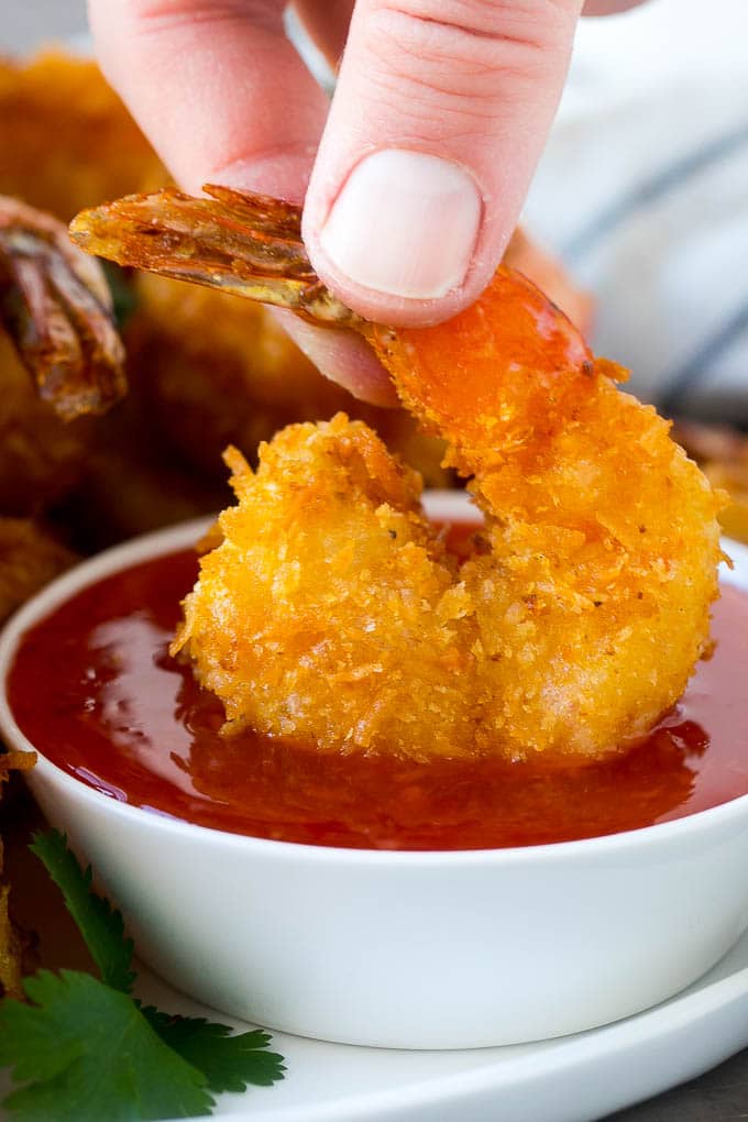 Coconut Shrimp Recipe | Fried Shrimp | Shrimp Appetizer #shrimp #coconut #appetizer #seafood #dinner #edsug A hand dipping a crispy prawn into a bowl of sweet chili sauce.
