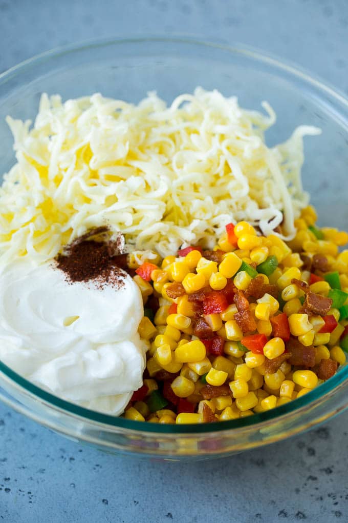 Corn Dip Recipe | Hot Cheese Dip | Bacon Dip #corn #dip #bacon #cheese #appetizer #snack #edsug Corn, bacon, bell peppers, sour cream and cheese in a mixing bowl.