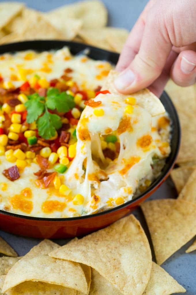 Corn Dip Recipe | Hot Cheese Dip | Bacon Dip #corn #dip #bacon #cheese #appetizer #snack #edsug A chip scooping up a serving of corn dip.