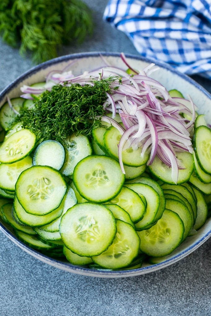 Creamy Cucumber Salad Recipe | German Cucumber Salad | Cucumber Salad #cucumber #salad #dinner #lunch #edsug #cucumbersalad Thinly sliced cucumbers, red onion and fresh dill in a mixing bowl.