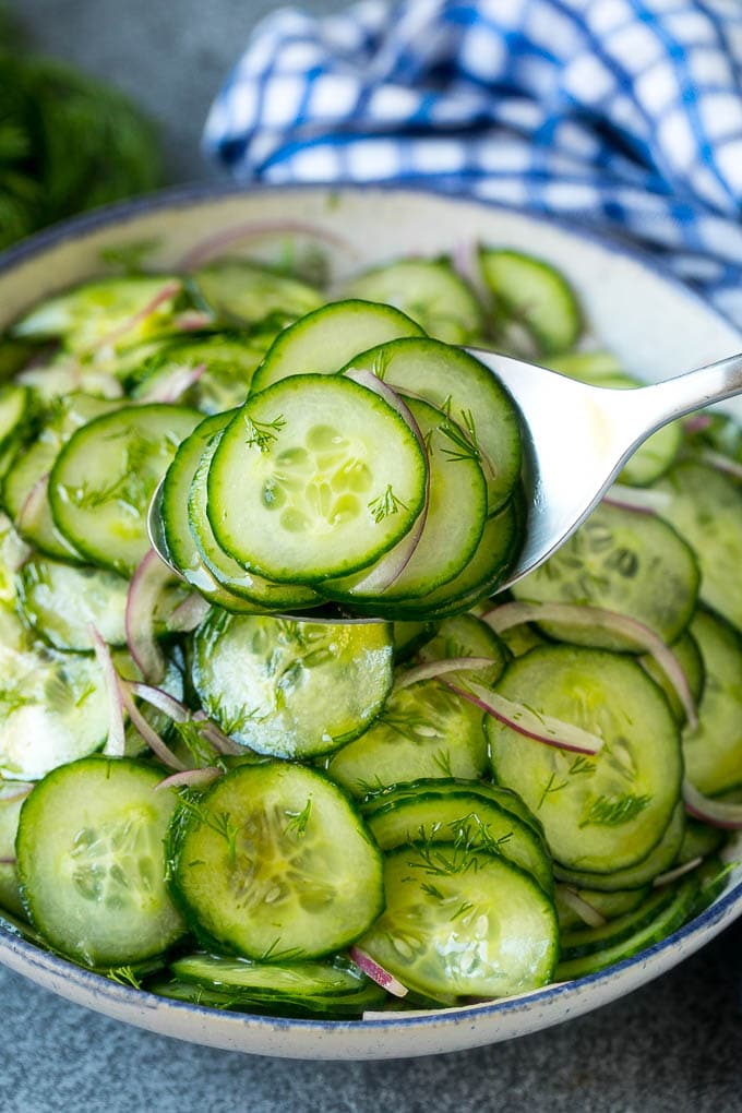 Cucumber Salad Recipe | Cucumber Dill Salad | Cucumber Recipe #cucumbers #salad #glutenfree #sidedish #edsug A spoon serving up a portion of classic cucumber salad.